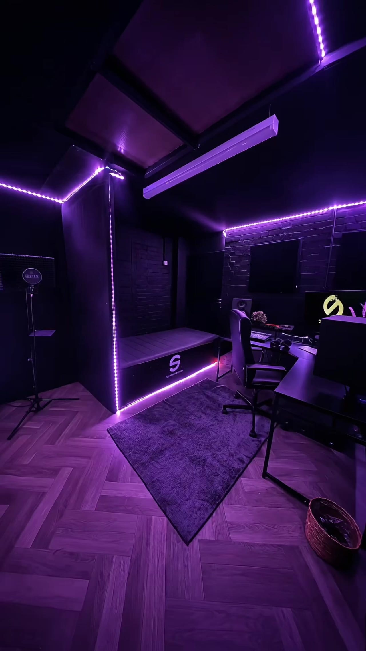 The music studio: studio monitors and a screen on the desk, acoustically treated walls.