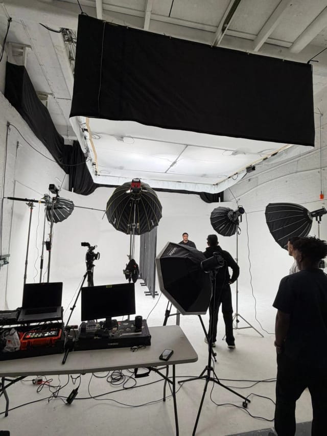 A full lighting crew working in Studio A with five softboxes, an overhead silk and a DIT table