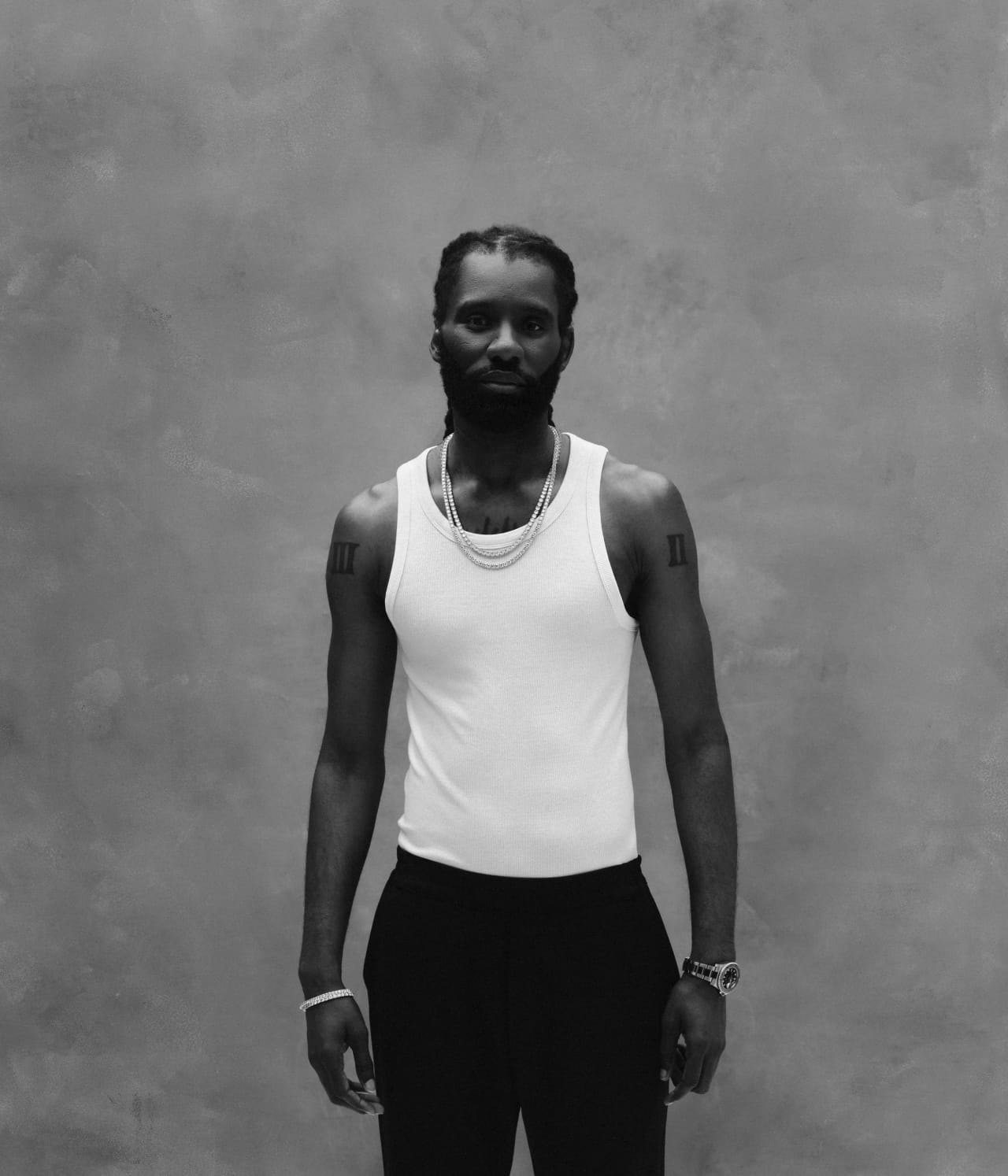 Full length black and white standing portrait on a mottled grey backdrop